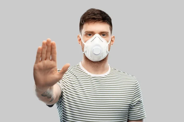 Man in respirator mask making stop gesture — Stock Photo, Image