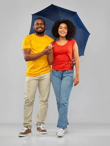 Usmívající se africký americký pár s deštníkem — Stock fotografie
