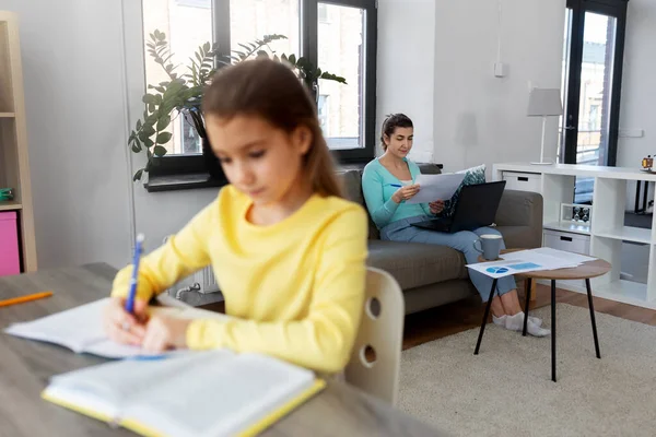 Мать работает и дочь учится на дому — стоковое фото