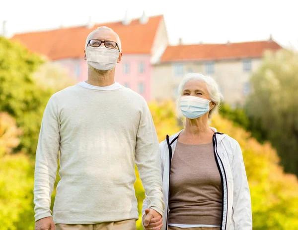 Dışarıda koruyucu sağlık maskeleri takan yaşlı çift. — Stok fotoğraf