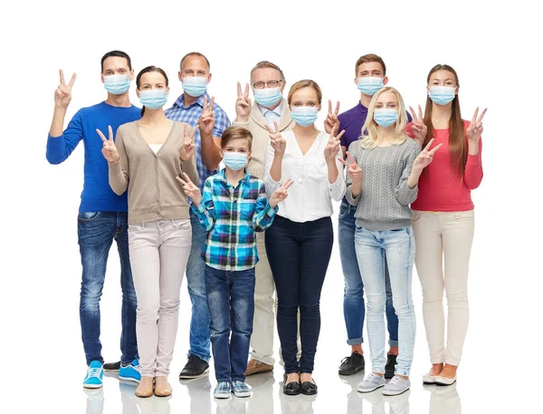 Люди в медицинских масках показывают знак мира — стоковое фото