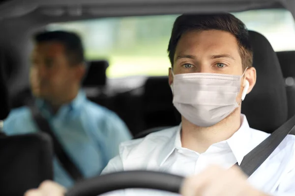 Taxi driver in face protective mask driving car — Stock Photo, Image