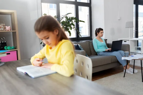 Madre che lavora e figlia che studia a casa — Foto Stock