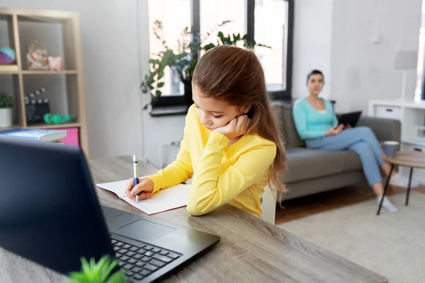 student girl with laptop learning online at home