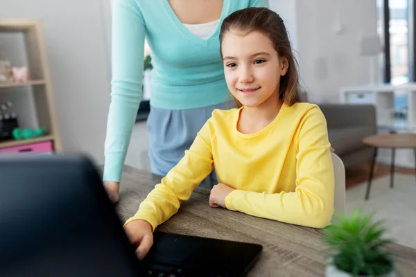 带着笔记本电脑做作业的母亲和女儿 — 图库照片