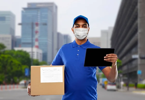Delivery man in mask με tablet pc και κουτί δεμάτων — Φωτογραφία Αρχείου