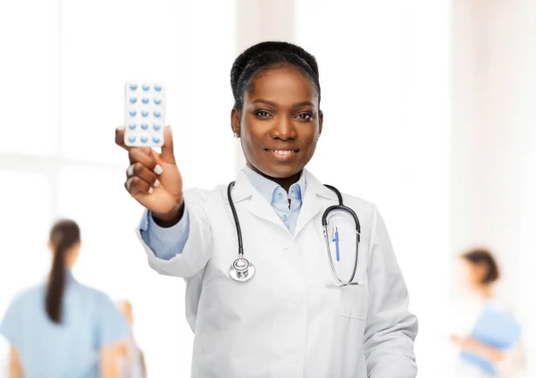 Afro-americana medico femminile con pillole di medicina — Foto Stock