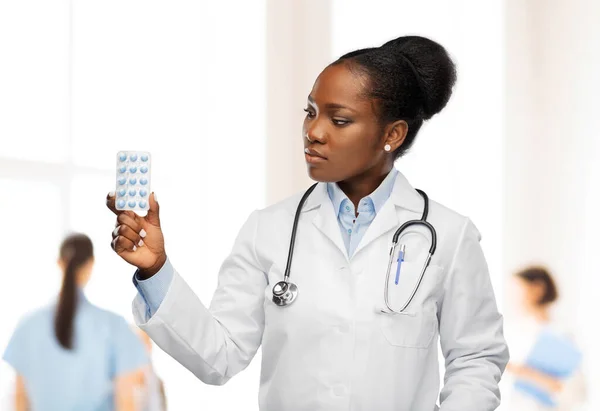 Afrykańska amerykańska lekarka z tabletkami. — Zdjęcie stockowe