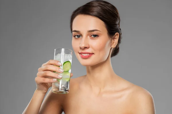 Kvinna dricksvatten med gurka och is — Stockfoto