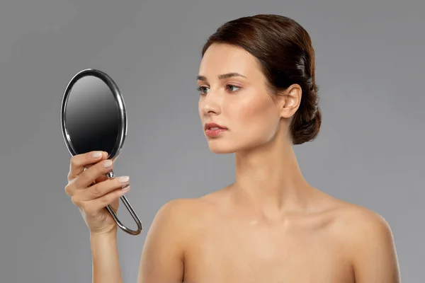 Beautiful young woman looking to mirror — Stock Photo, Image