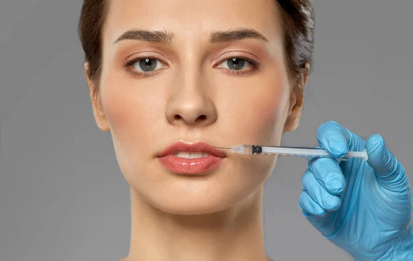 Beautiful young woman and hand with syringe — Stock Photo, Image