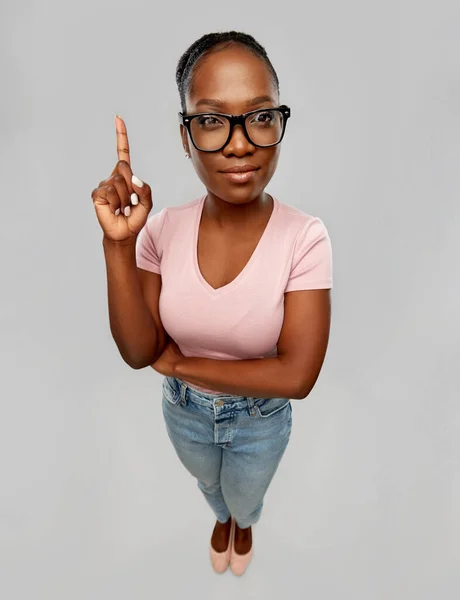 Afro-américaine femme en lunettes avec doigt vers le haut — Photo