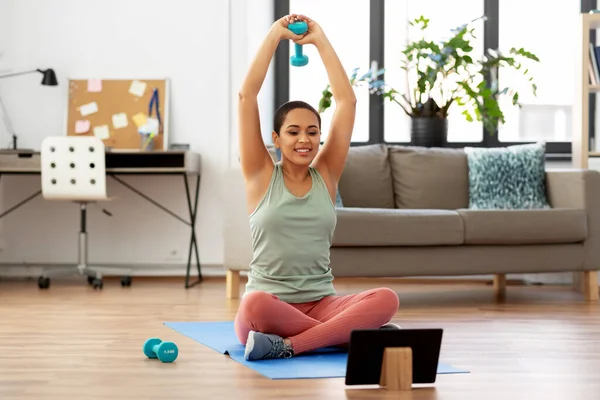 Mujer con Tablet PC y entrenamiento de mancuerna en casa — Foto de Stock