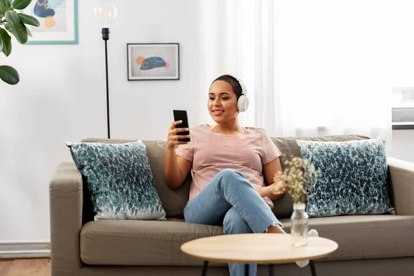 Mujer con smartphone escuchando música en casa — Foto de Stock