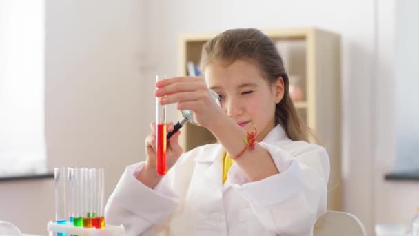 Девушка с увеличителем и стаканом в домашней лаборатории — стоковое видео