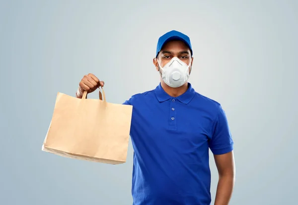 Delivery man in respirator mask with paper bag — Stock Photo, Image