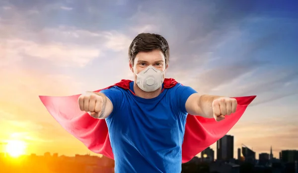 Superhero man in respirator flying over city — Stock Photo, Image