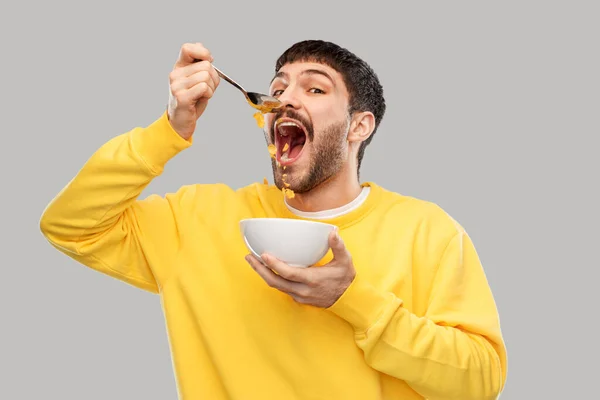 Nälkäinen nuori mies syö viljaa — kuvapankkivalokuva