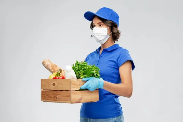 Mujer de entrega en mascarilla con comida en caja —  Fotos de Stock