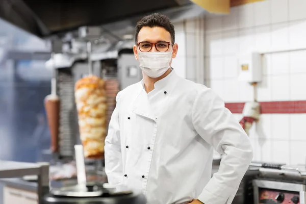 Chef masculin avec masque dans la cuisine du magasin de kebab Images De Stock Libres De Droits