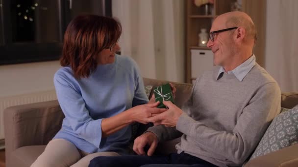 Счастливая старшая пара с подарочной коробкой дома — стоковое видео