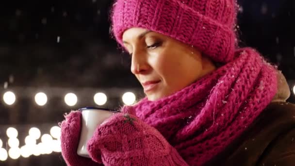 Счастливая молодая женщина пьет чай на открытом воздухе зимой — стоковое видео