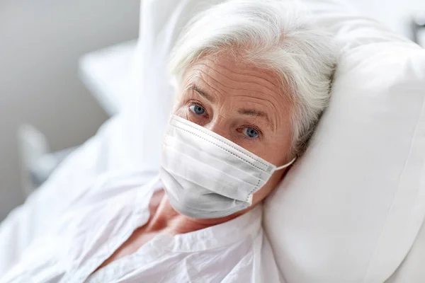Anciana paciente con máscara acostada en la cama en el hospital —  Fotos de Stock