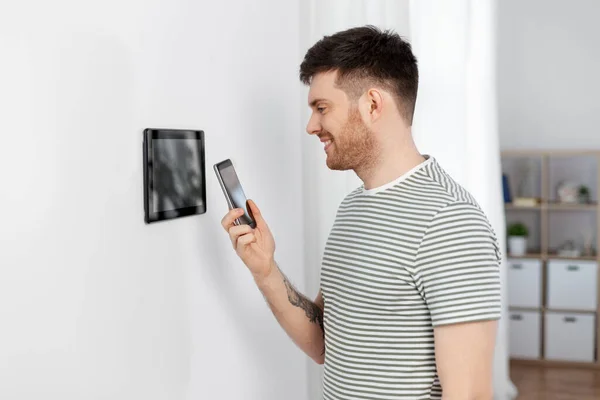 Glimlachende man met behulp van tablet computer in smart home — Stockfoto