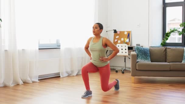 Африканская женщина делает упражнения на выпад дома — стоковое видео