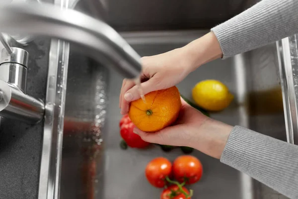 Mulher lavando frutas e legumes na cozinha — Fotografia de Stock