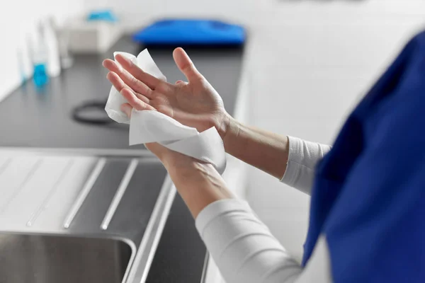 Doctor or nurse drying hands with paper tissue — Stock Photo, Image