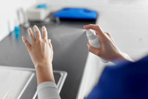 Врач или медсестра, распыляющие средства для дезинфекции рук — стоковое фото