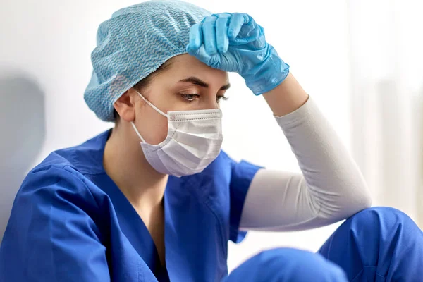 Trauriger Arzt oder Krankenschwester mit Mundschutz — Stockfoto