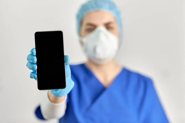 Dokter in bril en gezichtsmasker met smartphone — Stockfoto