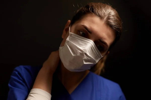 Tired female doctor or nurse in medical face mask — Stock Photo, Image