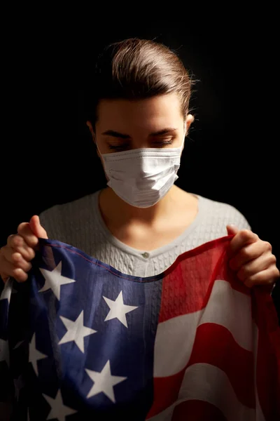 头戴口罩、拿着美国国旗的生病妇女 — 图库照片