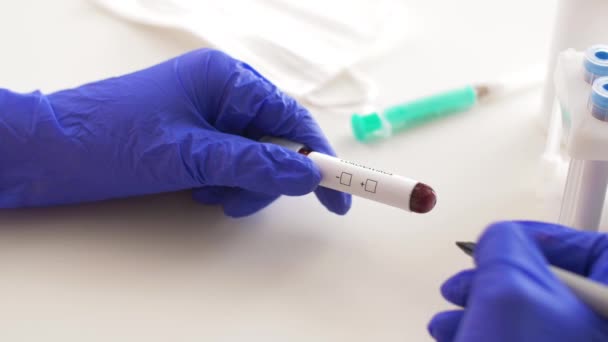 Рука тримає міхур з аналізом крові на коронавірус — стокове відео