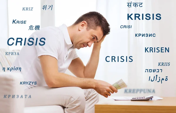Hombre estresado con dinero y calculadora en casa —  Fotos de Stock