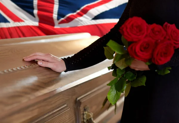 Mulher com rosas vermelhas e caixão sobre bandeira inglesa — Fotografia de Stock