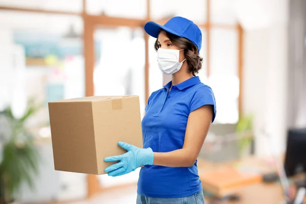 Mujer de entrega en máscara con caja de paquete en la oficina — Foto de Stock