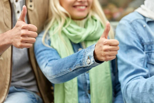 Close up of smiling friends showing thumbs up — Stock Photo, Image