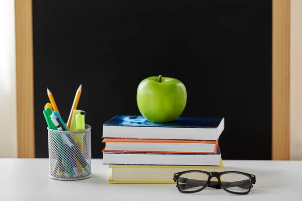 Libros, manzanas y útiles escolares en la mesa en casa — Foto de Stock