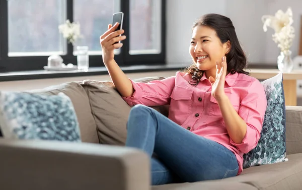 Kvinna med smartphone med videosamtal hemma — Stockfoto