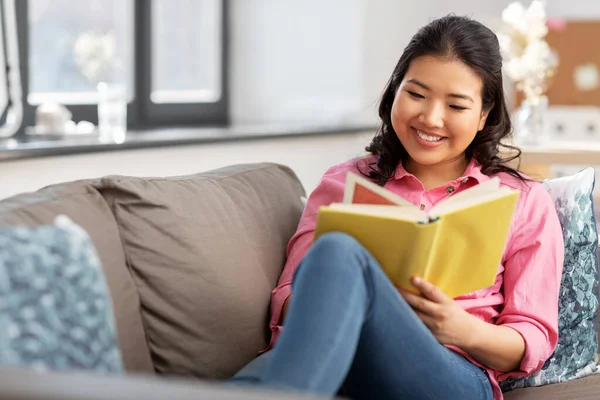 アジア系の若い女性が家で本を読んで — ストック写真