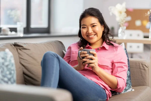 Sonriente asiático joven mujer bebiendo café en casa — Foto de Stock