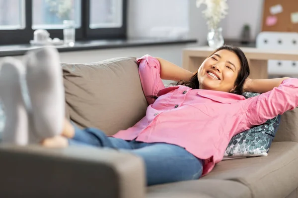 Счастливая женщина, лежащая на диване и мечтающая — стоковое фото