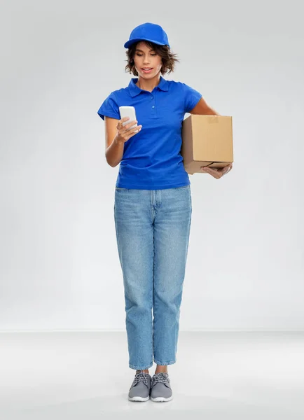 Mujer de entrega con teléfono inteligente y caja de paquetes — Foto de Stock
