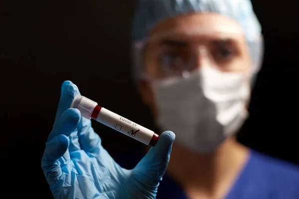 Médico segurando copo com coronavírus teste de sangue — Fotografia de Stock