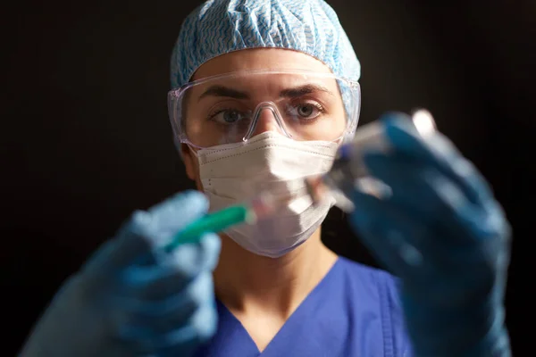 Läkare i ansiktsmask med spruta och medicin — Stockfoto