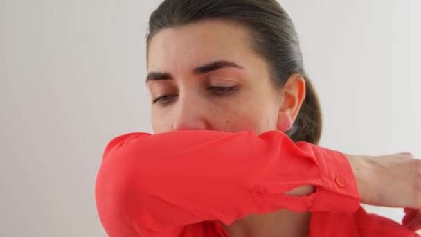 Женщина кашляет, закрывая рот локтем — стоковое видео
